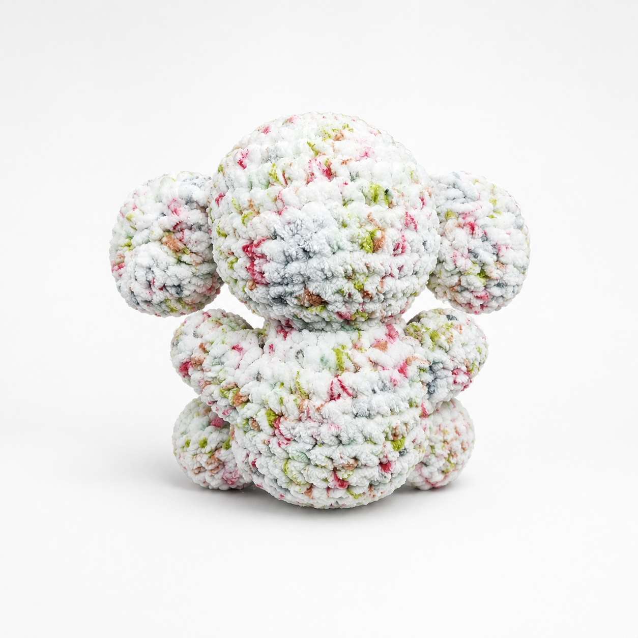 Back view of handmade crochet elephant plush in speckled white yarn.