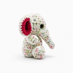 Side view of handmade crochet elephant plush showing the trunk, ear, and rounded body.